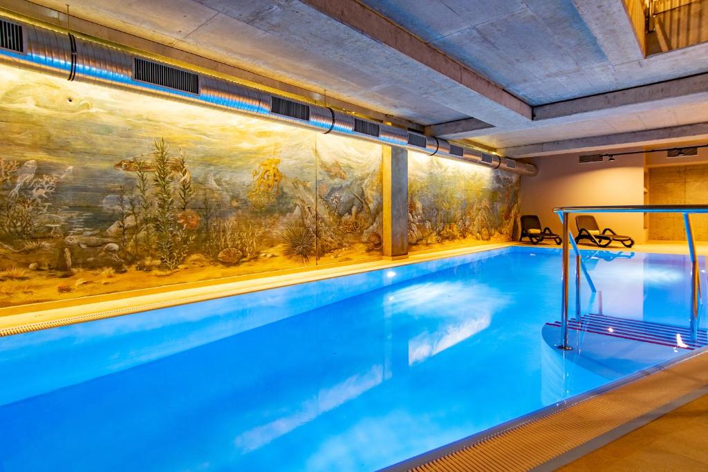a large swimming pool with a painting on the wall at Hotel am Fischerstrand in Bansin