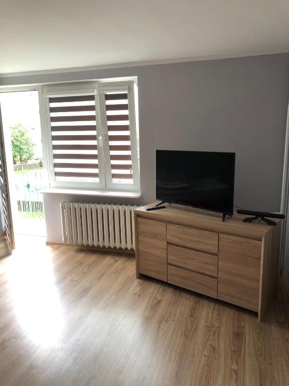 a living room with a flat screen tv on a dresser at Apartament dwa pokoje Dęblin in Dęblin
