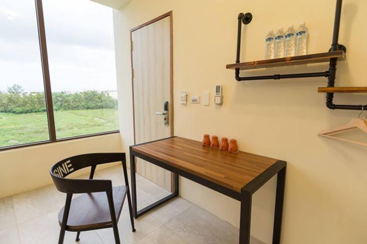 a room with a desk and a chair and a window at Sheng Tu Villa in Hengchun South Gate