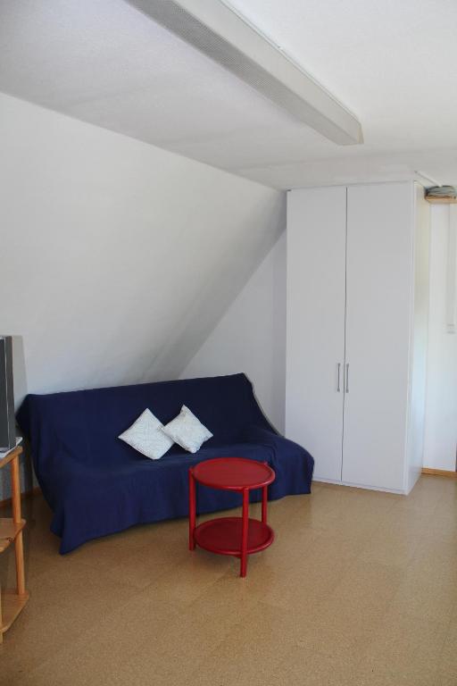1 dormitorio con 1 cama azul y 1 silla roja en FeWo am Schlossberg, en Neusitz