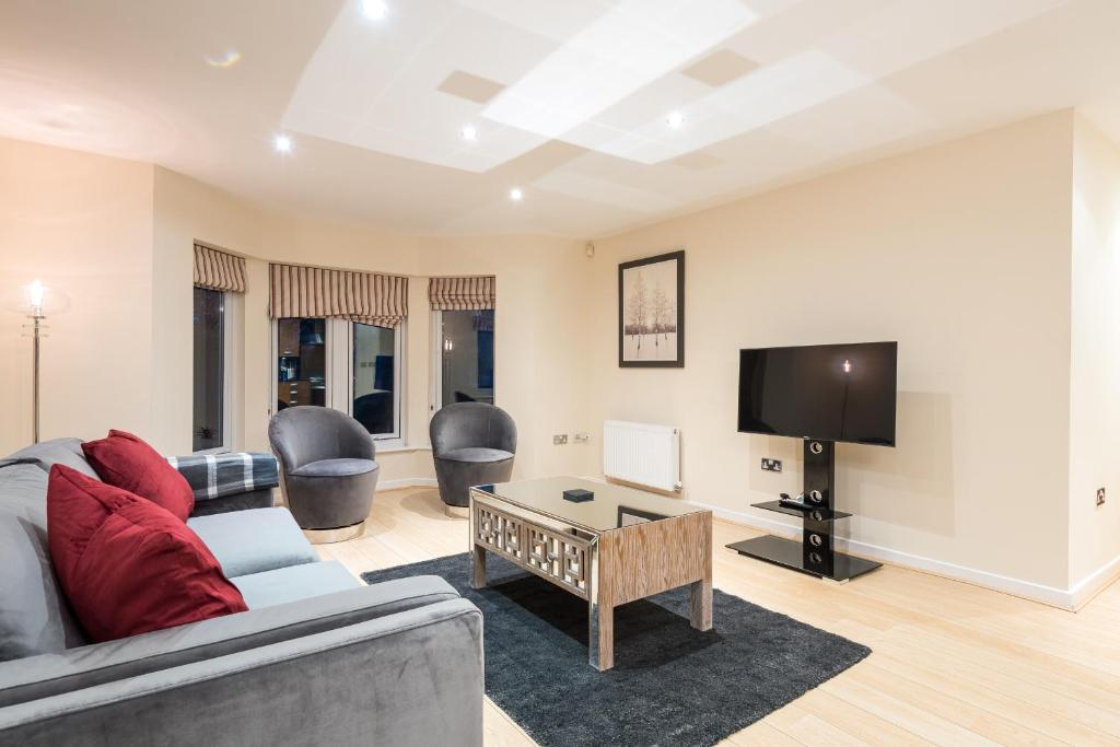 a living room with a couch and a tv at Modern Smart Open Plan Living with free Parking in York
