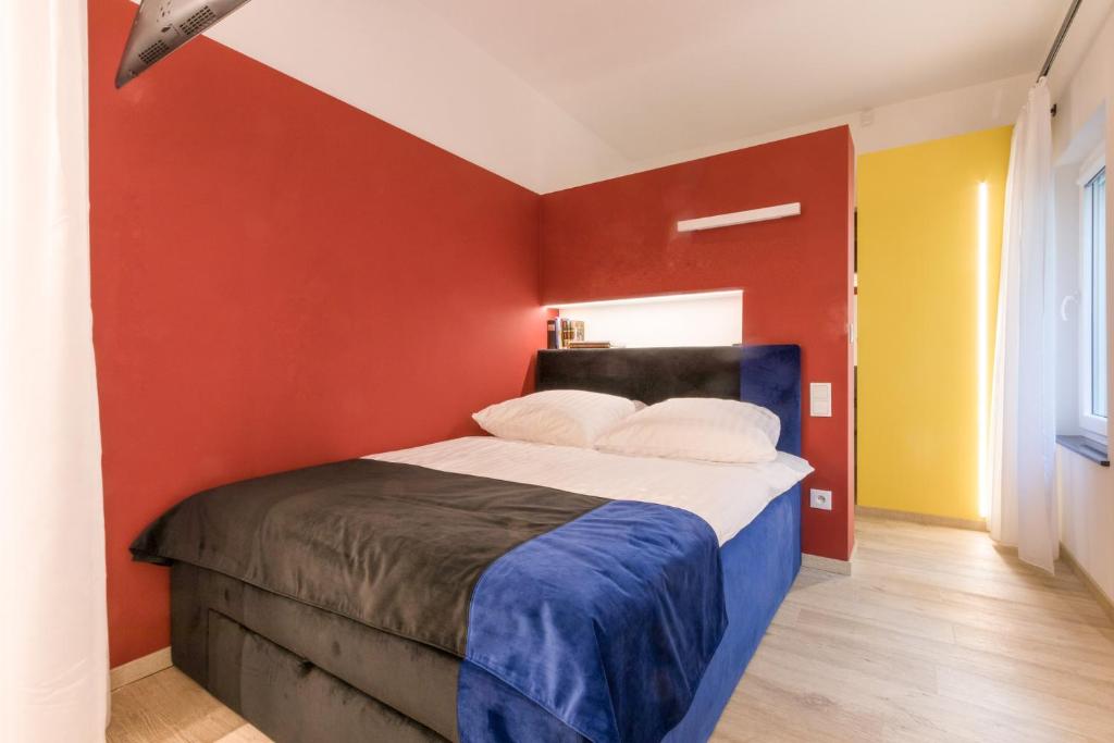 a bedroom with a bed with red and yellow walls at Apartment KOBRO - new city center of Lodz in Łódź