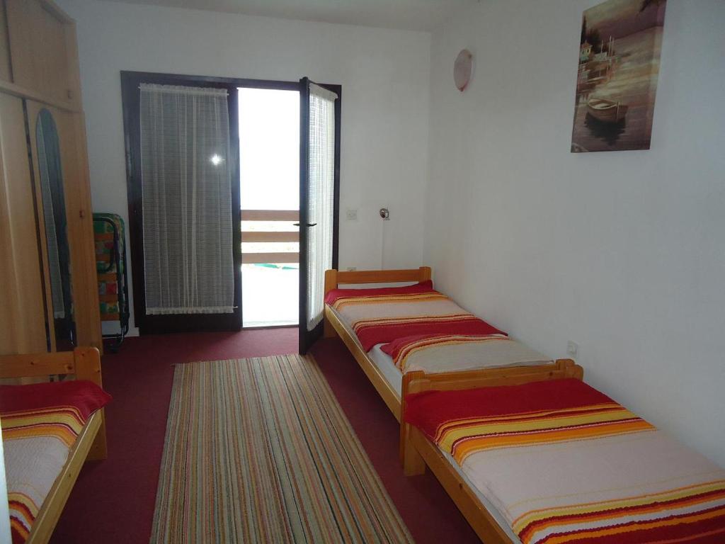 3 camas están alineadas en una habitación en Apartments Jelekovac, en Sveti Petar