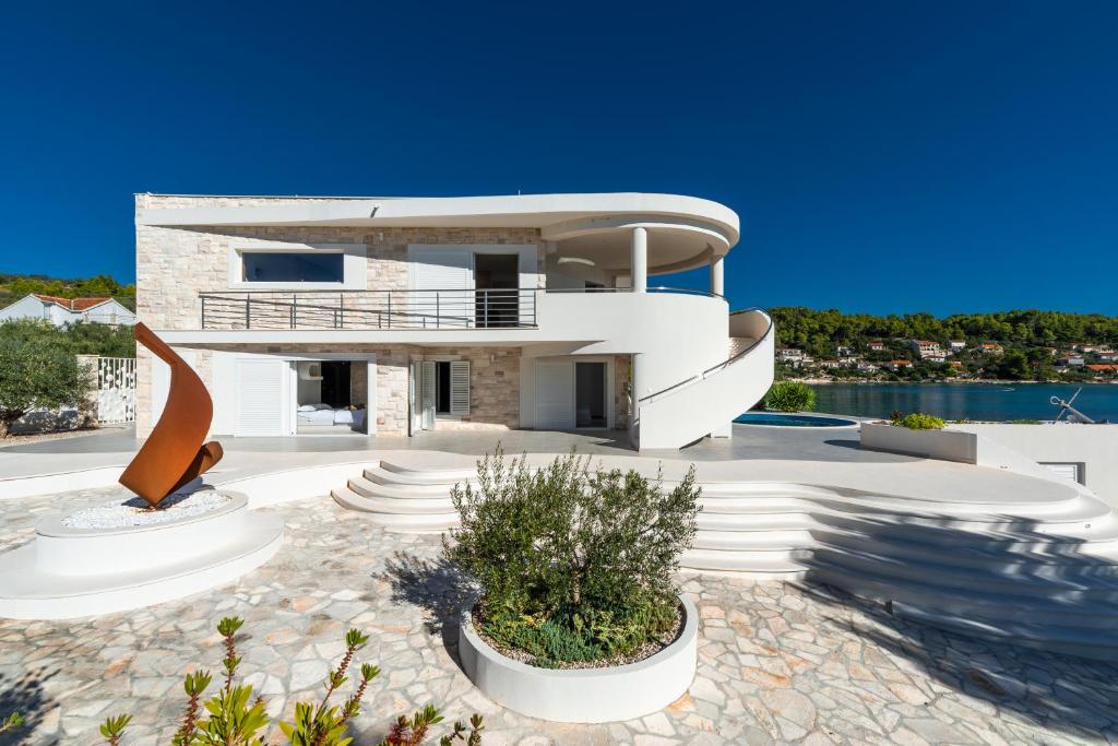 a large white house with a view of the water at Villa Soleil in Vela Luka