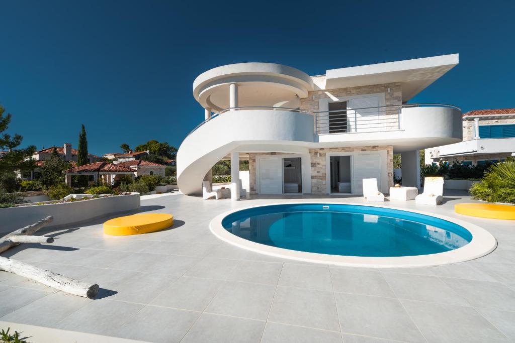 a villa with a swimming pool in front of a house at Villa Soleil in Vela Luka