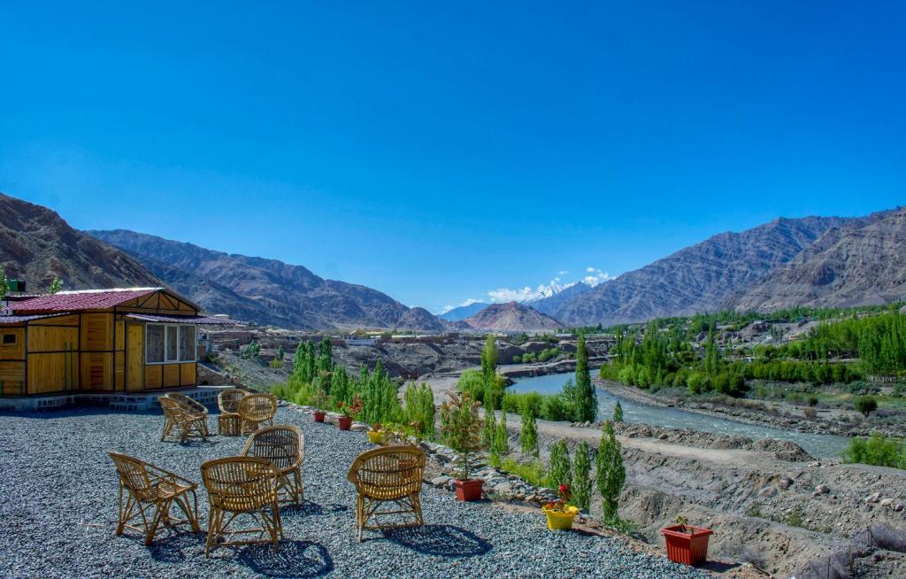 a resort with a view of a river and mountains at Neryok's Indus view in Chimre