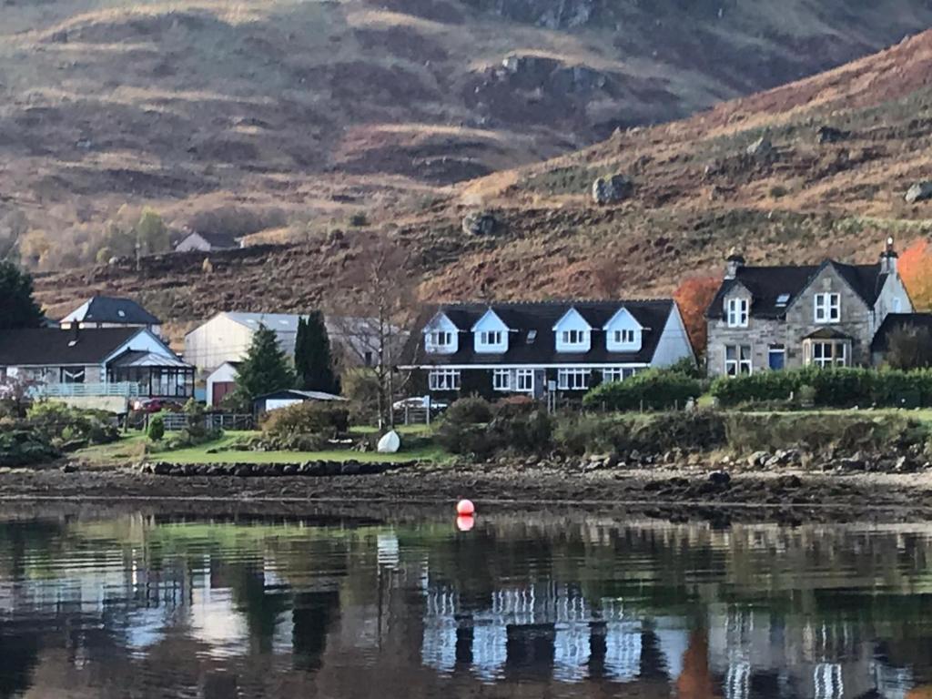 een groep huizen aan de oever van een waterlichaam bij Rowan House B&B Rooms & A Self Catering Apartment in Lochgoilhead