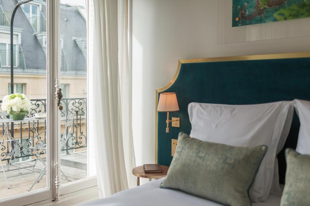 a bedroom with a bed and a balcony at Hôtel Alfred Sommier in Paris
