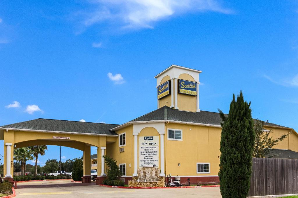 a yellow building with a clock tower on top at Scottish Inn and Suites Baytown in Baytown