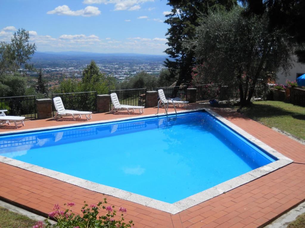 a swimming pool with chairs and a view of the city at Nido d'Aquila in Collodi