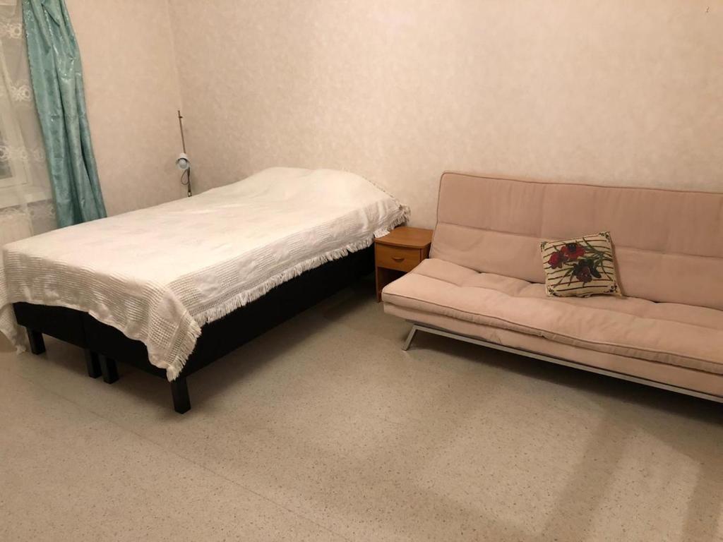 a small bedroom with a bed and a couch at Kontiomaki in Kontiomäki