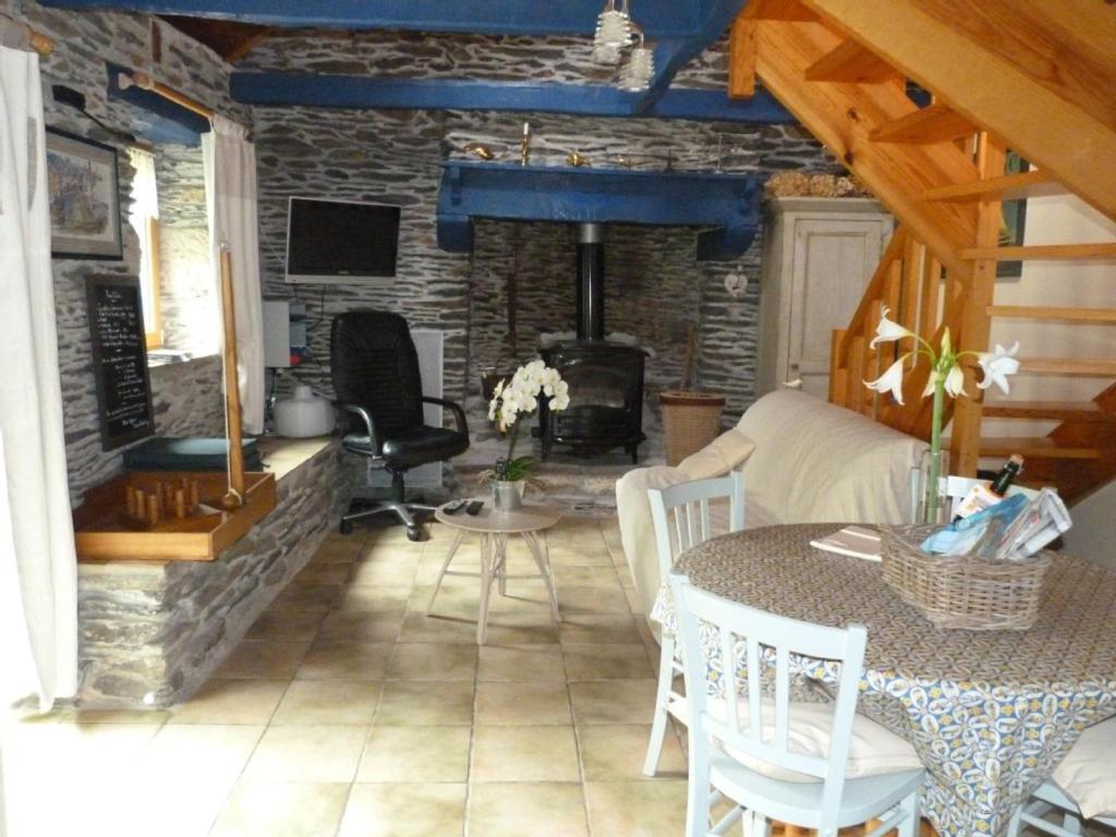 a living room with a table and a fireplace at A L'Ombre Du Figuier in Saint-Thois
