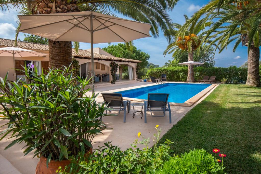 een patio met een parasol en een zwembad bij Finca Polita in Felanitx