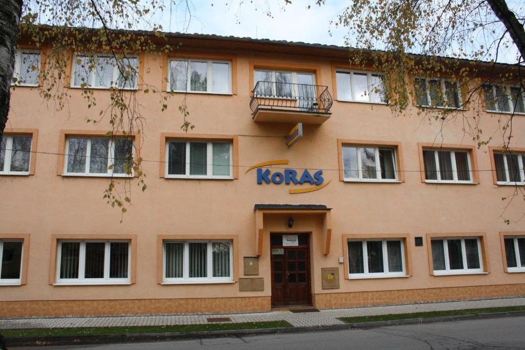 een gebouw met een kronkelbord aan de voorzijde bij Penzión Koras in Vrútky