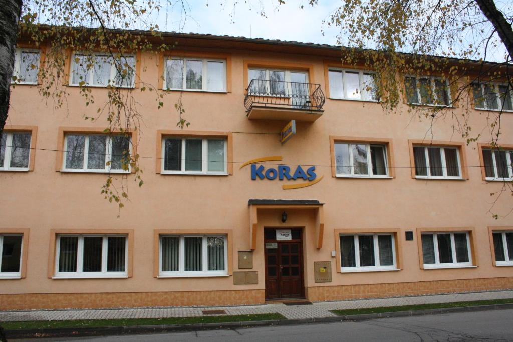 a building with a kinks sign on the front of it at Penzión Koras in Vrútky