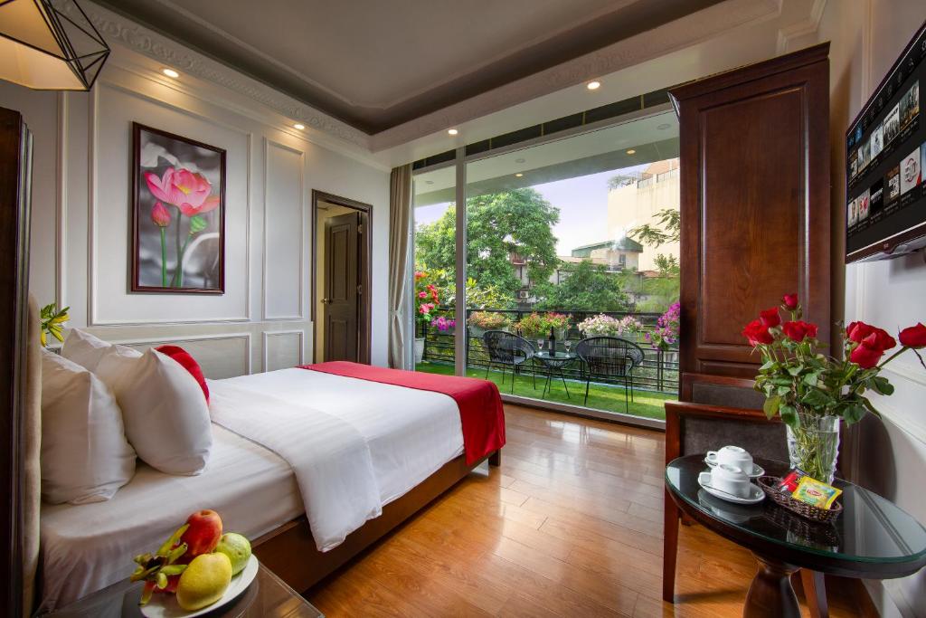 a bedroom with a bed and a large window at Hanoi Royal Palace Hotel 2 in Hanoi