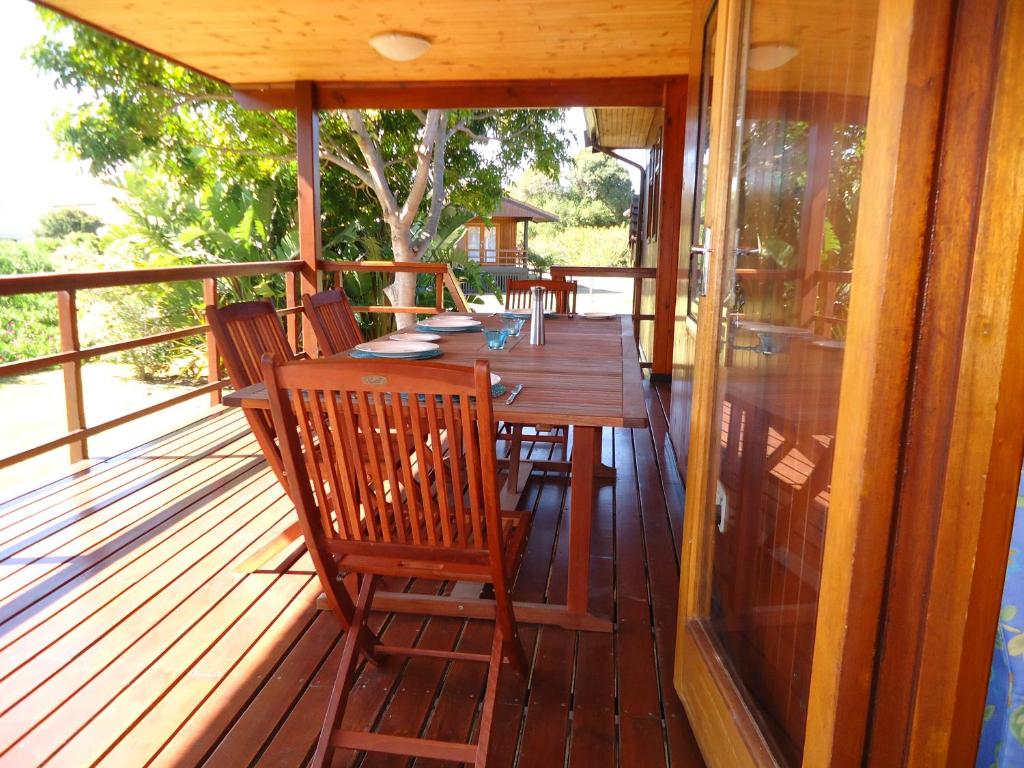 a wooden deck with a wooden table and chairs at 5 Dune Park in Keurboomstrand