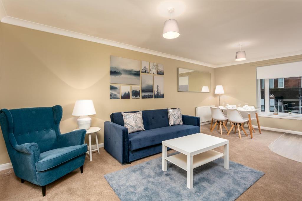Cairn Suite - Donnini Apartments في آير: غرفة معيشة مع كرسيين ازرق وطاولة