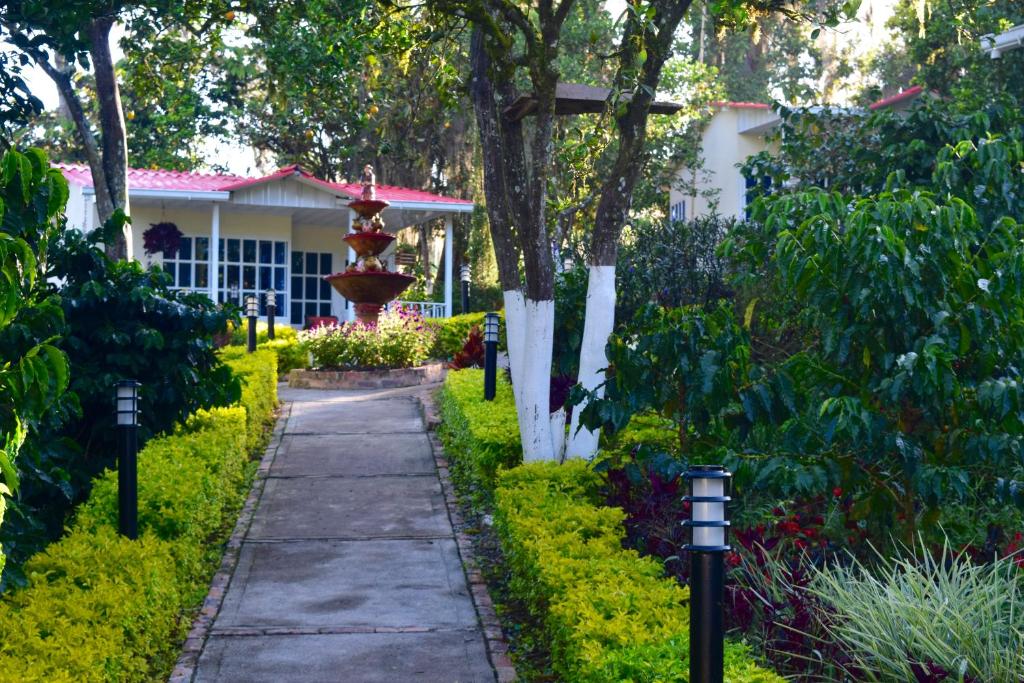 a garden path in front of a house with a fountain at Hostal Fisterra in Moniquirá