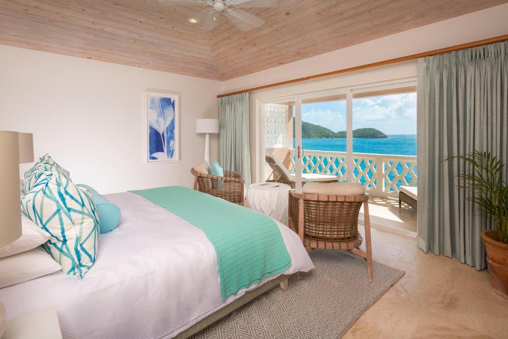 um quarto com uma cama e vista para o oceano em Curtain Bluff - All Inclusive em Old Road