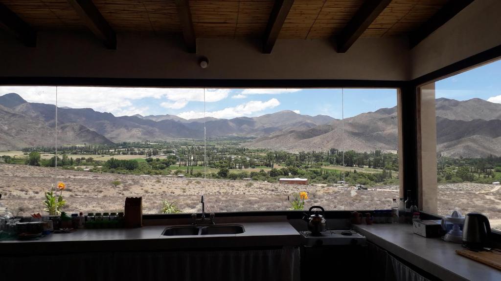 a kitchen window with a view of the mountains at Cabaña Abra Del Monte in Cachí