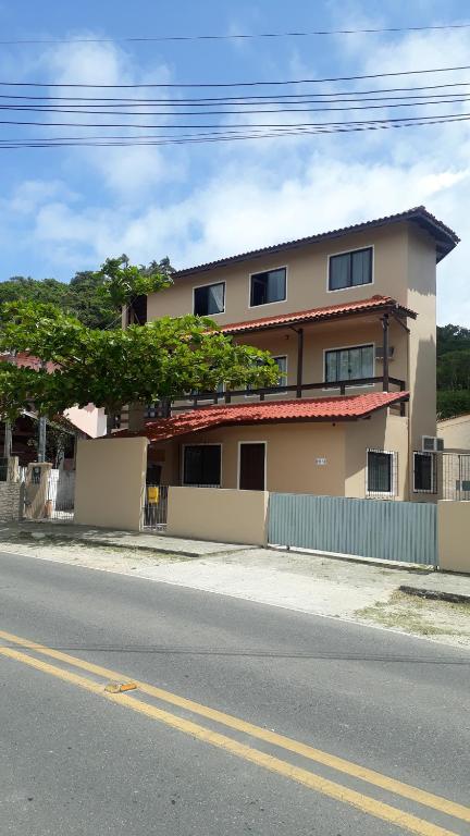 un edificio al lado de una calle con una valla en Apartamento Ponta das Canas, en Florianópolis