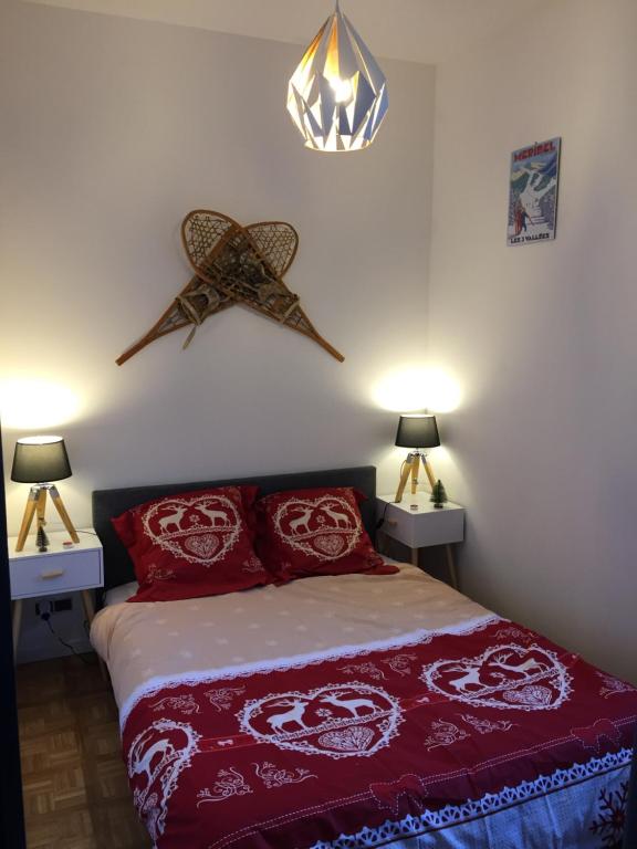 sypialnia z łóżkiem z czerwonymi poduszkami w obiekcie Appartement Orelle - Val Thorens w mieście Orelle