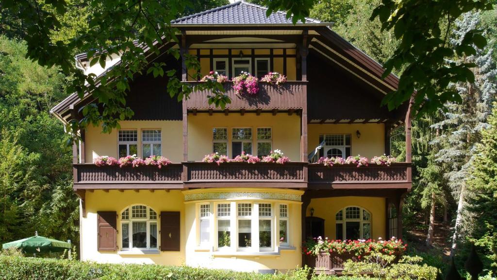 a yellow house with flowers on the balcony at Villa Liliengrund in Eisenach