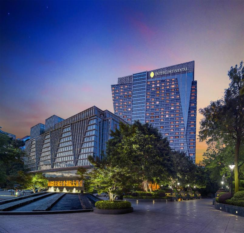 um edifício alto numa cidade à noite em InterContinental Century City Chengdu, an IHG Hotel em Chengdu