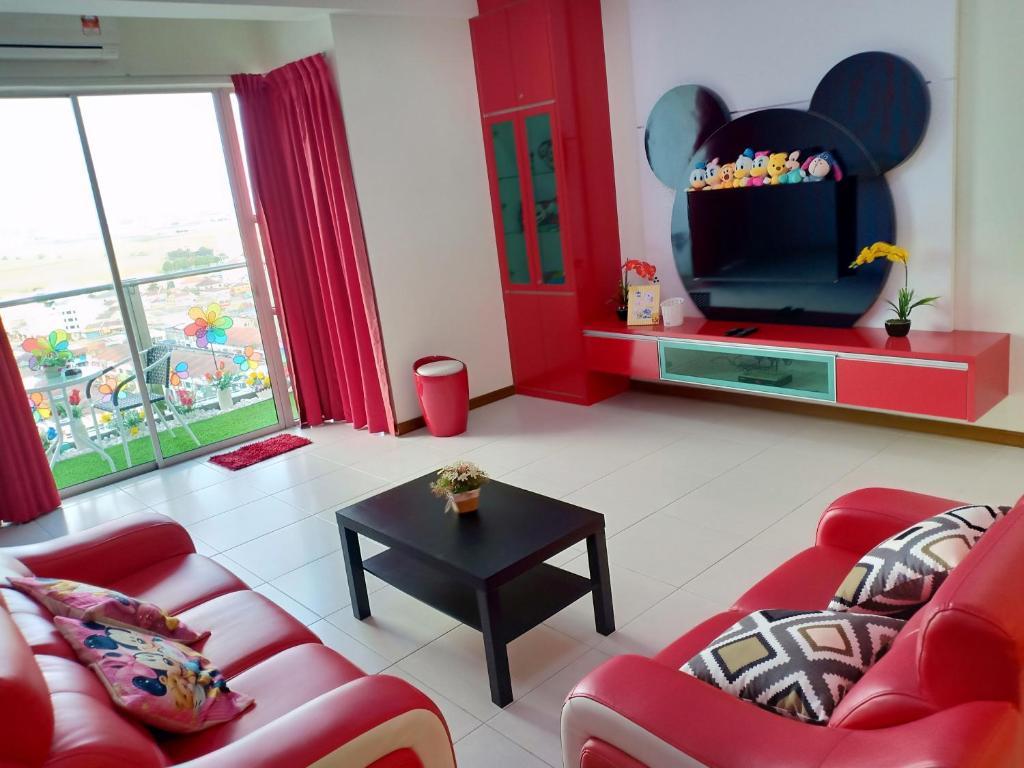a living room with red furniture and a flat screen tv at WindMill SunRise PaddyView Homestay in Sekincan