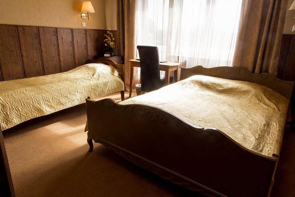 a hotel room with two beds and a chair at Vahe Guest House in Põltsamaa