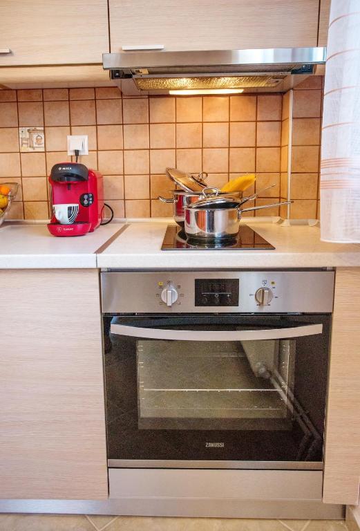 a kitchen with a stove with a pot on it at Konstantina & Evgenia Deluxe Apartment in Nea Peramos