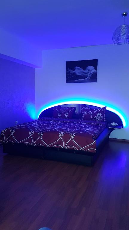a bedroom with a bed with a blue lighting at Relax 2 Central Apartment in Bacău