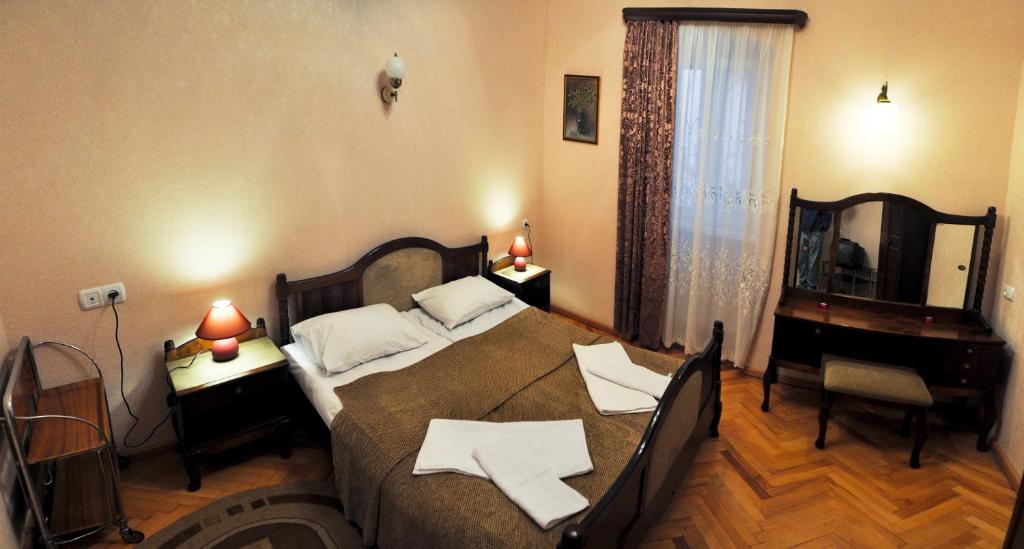 a bedroom with a bed and a desk and a piano at Apartment Old Street Dadiani 7 in Tbilisi City