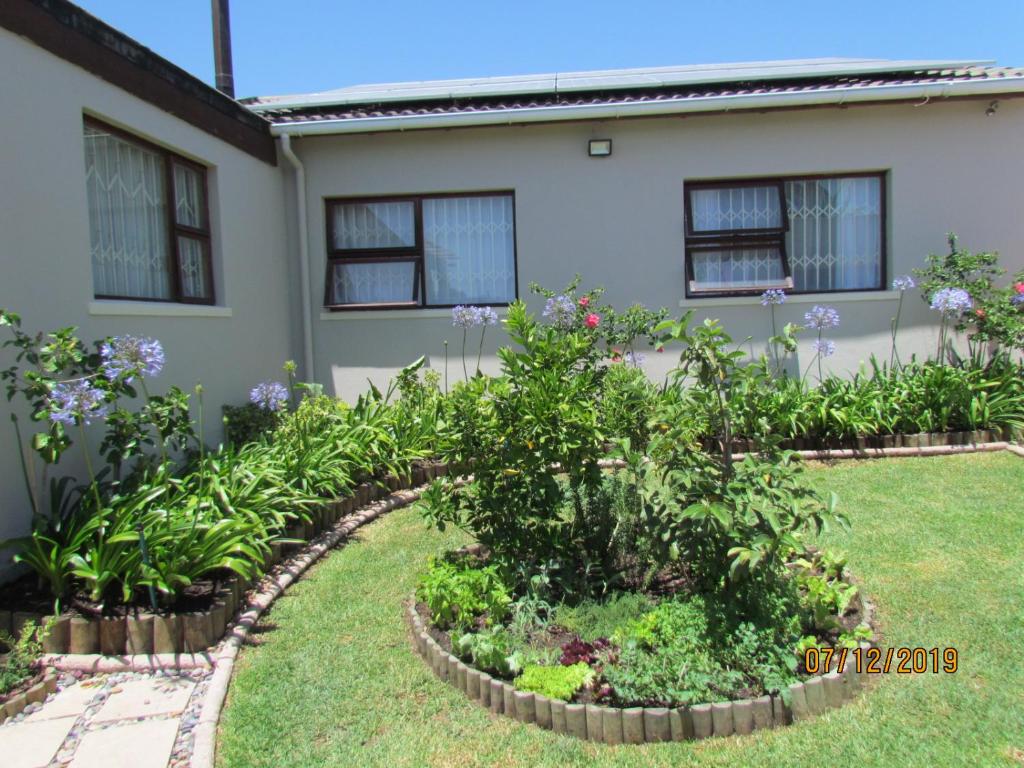 a garden in front of a house with plants at Princess Holiday Home in Cape Town