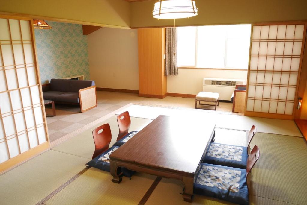 a living room with a table and chairs at Case House Hokkaido / Vacation STAY 61607 in Higashikawa