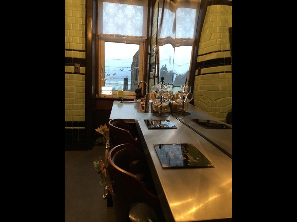 ポート・グラスゴーにあるVictorian flatのテーブル、椅子、窓が備わる客室です。