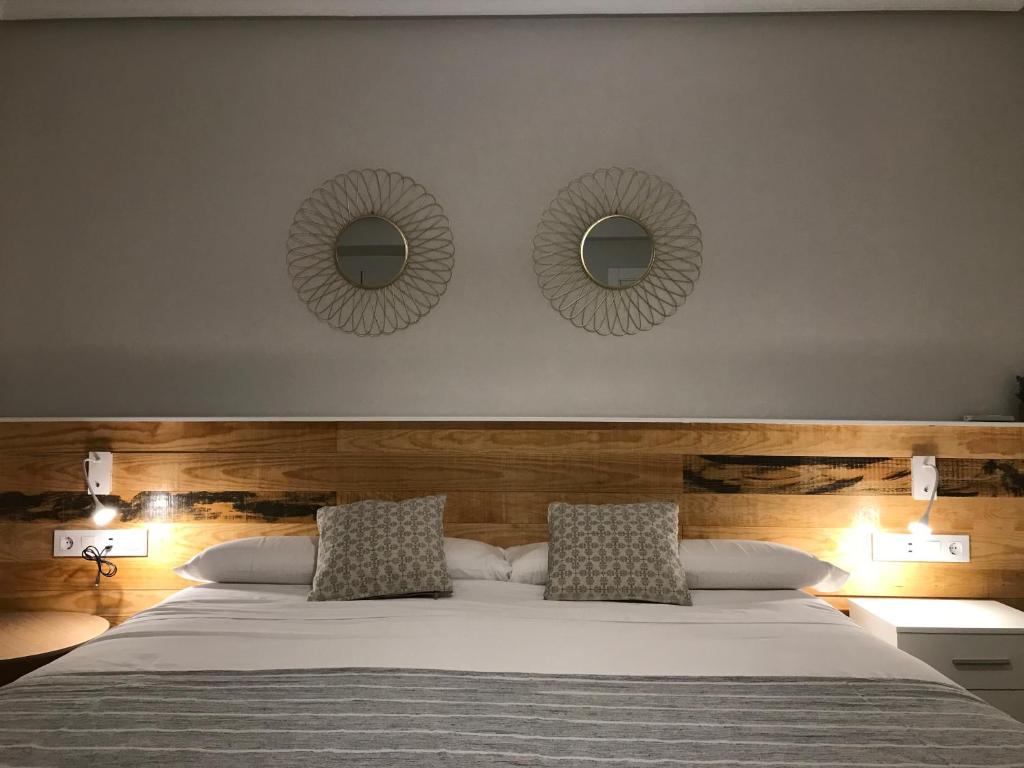 een slaapkamer met een bed met twee spiegels aan de muur bij Apartamento Abuelo Mayorga in Plasencia