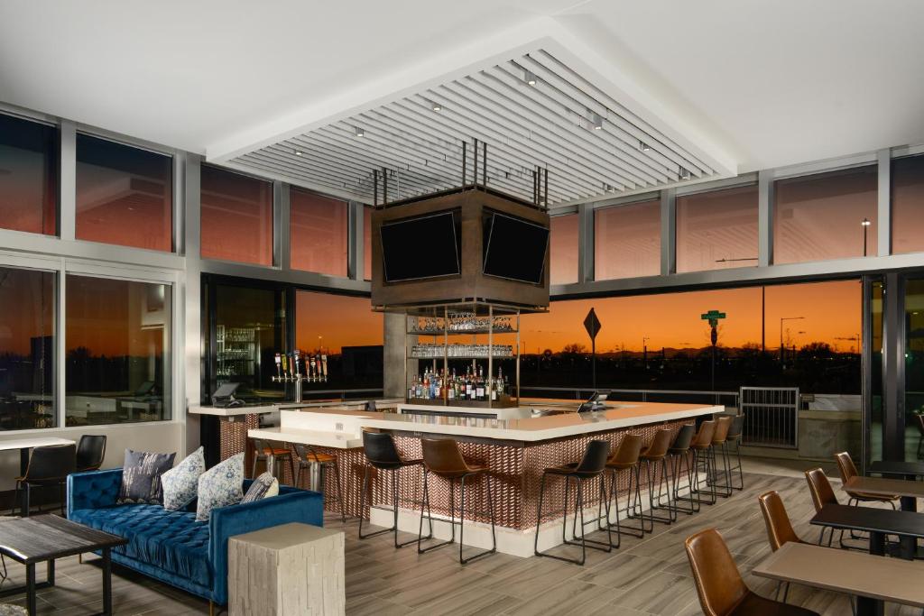 a lobby with a bar with a view of the city at Hyatt Place Pena Station/Denver Airport in Denver