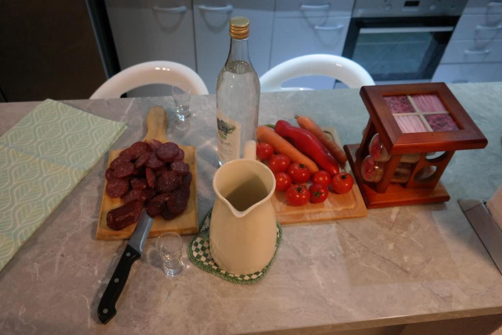 a counter top with vegetables and a bottle of wine at Gorski cvijet in Delnice