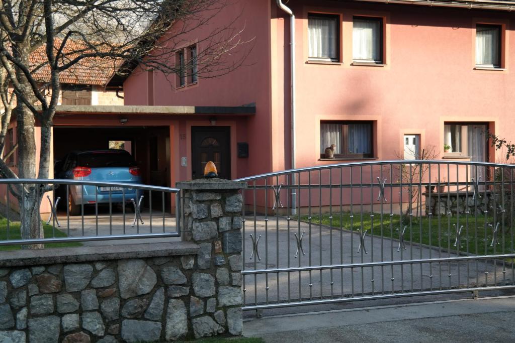 a pink building with a gate and a fence at Gorski cvijet in Delnice