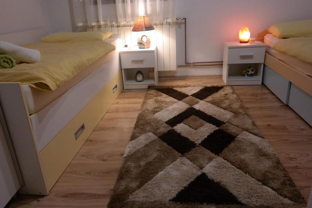 a bedroom with two beds and a rug at Gorski cvijet in Delnice