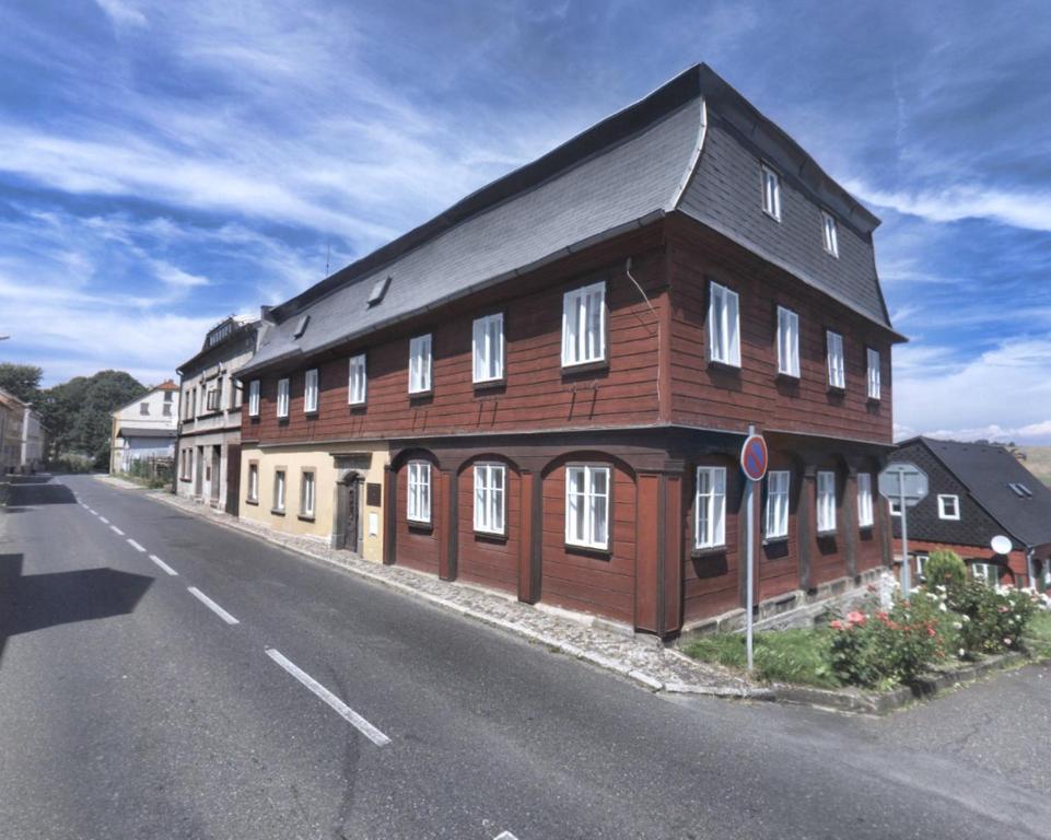 ein großes Holzgebäude an der Straßenseite in der Unterkunft Jiřetínská chaloupka in Jiřetín pod Jedlovou