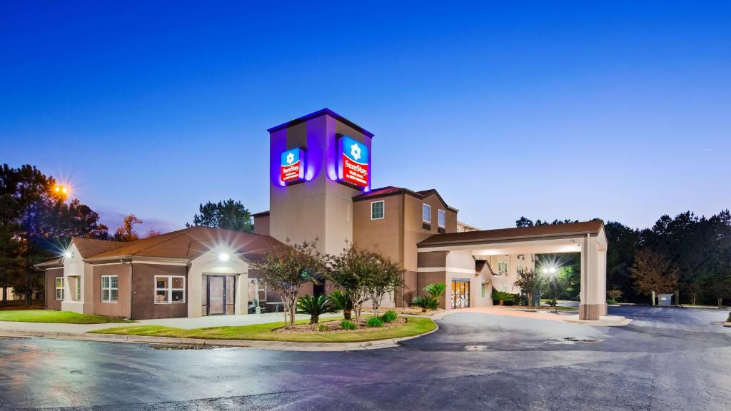 un hôtel avec un panneau au-dessus d'un bâtiment dans l'établissement SureStay Plus Hotel by Best Western Macon West, à Macon