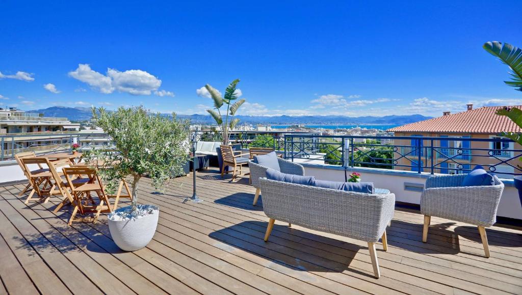 a deck with chairs and tables on a roof at Best Western Hôtel Journel Antibes Juan-les-Pins in Antibes