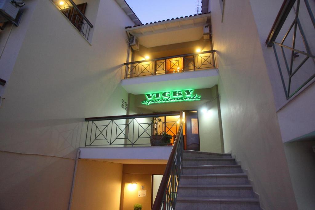 schody prowadzące do budynku z neonem w obiekcie Vicky Apartments w mieście Nikiana