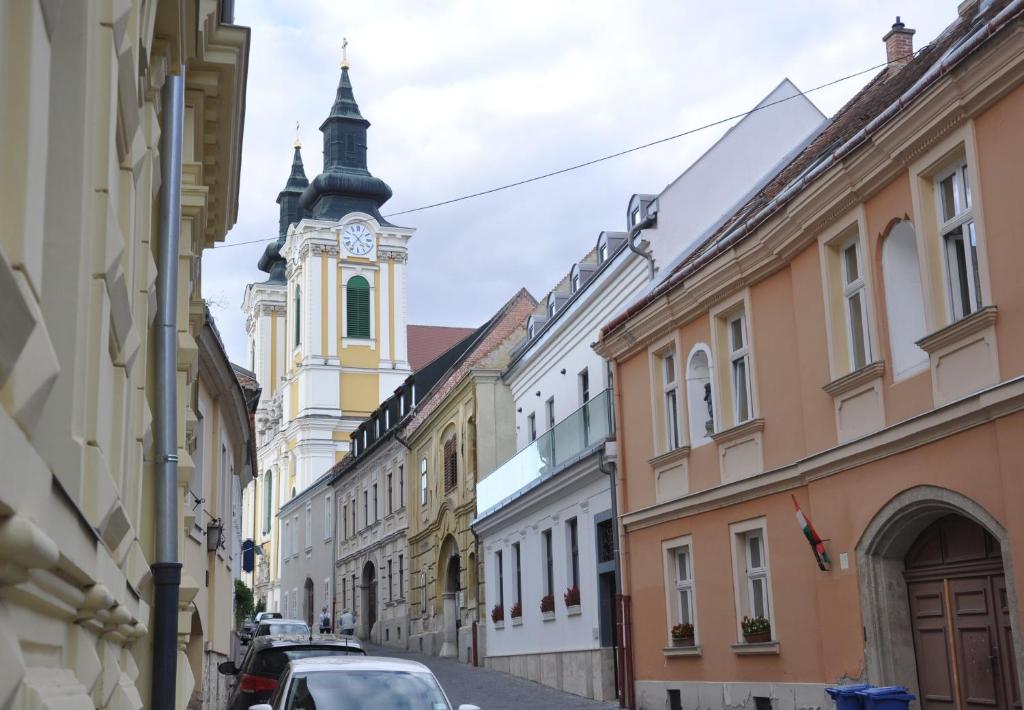 una calle de la ciudad con una torre del reloj y edificios en Centrál Vendégház Székesfehérvár, en Székesfehérvár