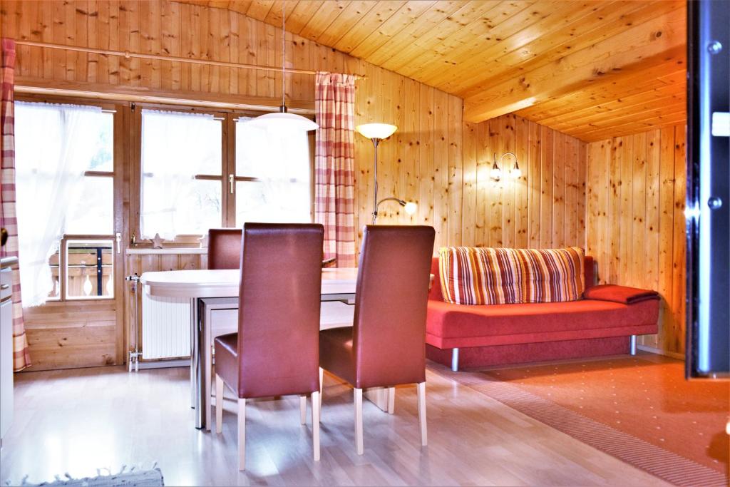 a dining room with a table and chairs and a couch at Haus Grassa in Brand