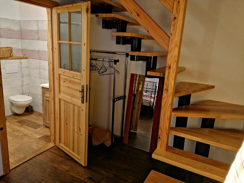 a room with a spiral staircase and a refrigerator at Siedlisko Zakucie in Jaśliska