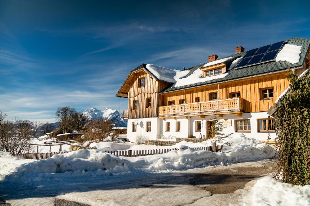 a house with a solar roof in the snow at Klausnerhof in Aich
